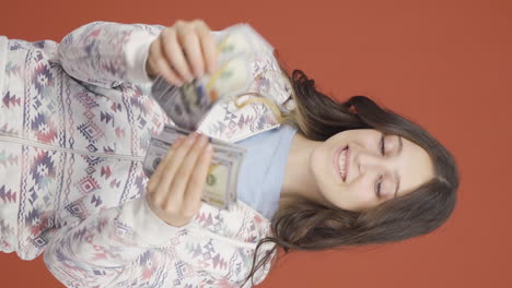 Vertical-video-of-Young-woman-counting-money-looking-at-camera.